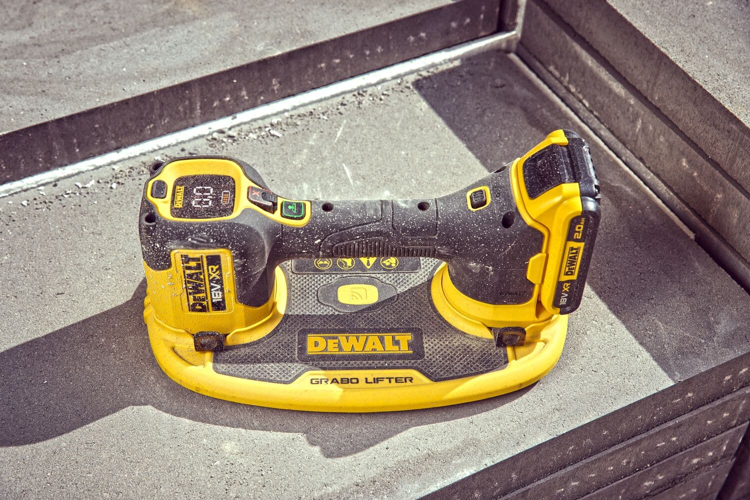 DEWALT Grabo Lifter tool placed on concrete steps, featuring a yellow and black design for lifting materials.