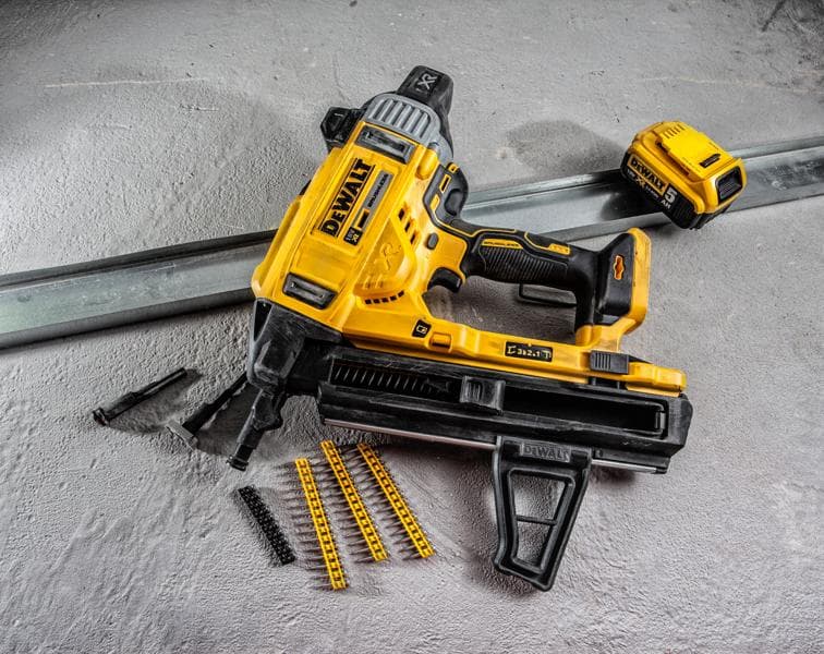 A DEWALT DCN890P2 cordless nail gun is shown on a concrete surface, alongside a battery pack, metal strip, nail cartridges