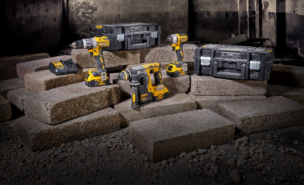 DEWALT power tools and toolboxes arranged on concrete blocks in an industrial setting.