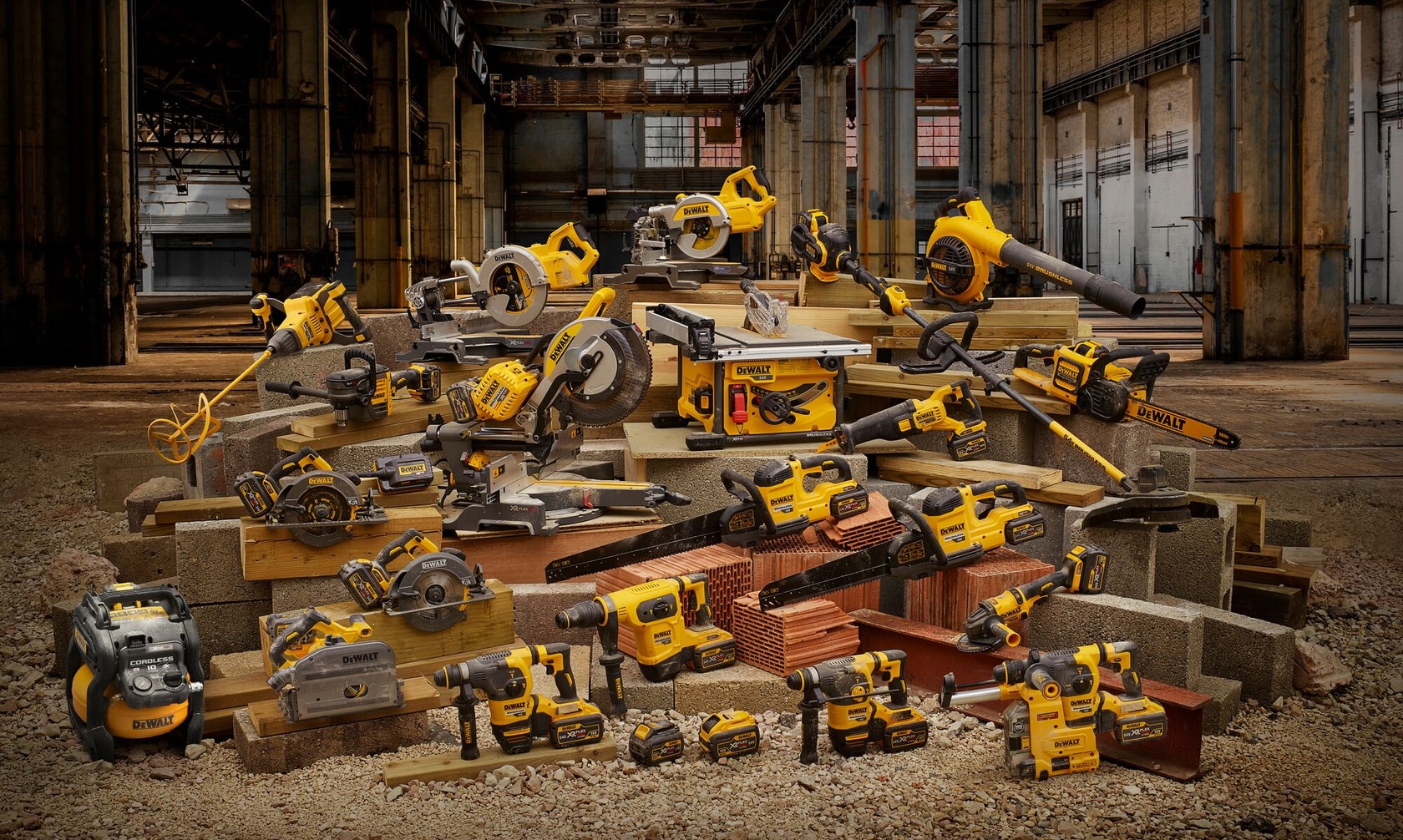 Multiple yellow DEWALT power tools arranged on construction materials in a warehouse setting.