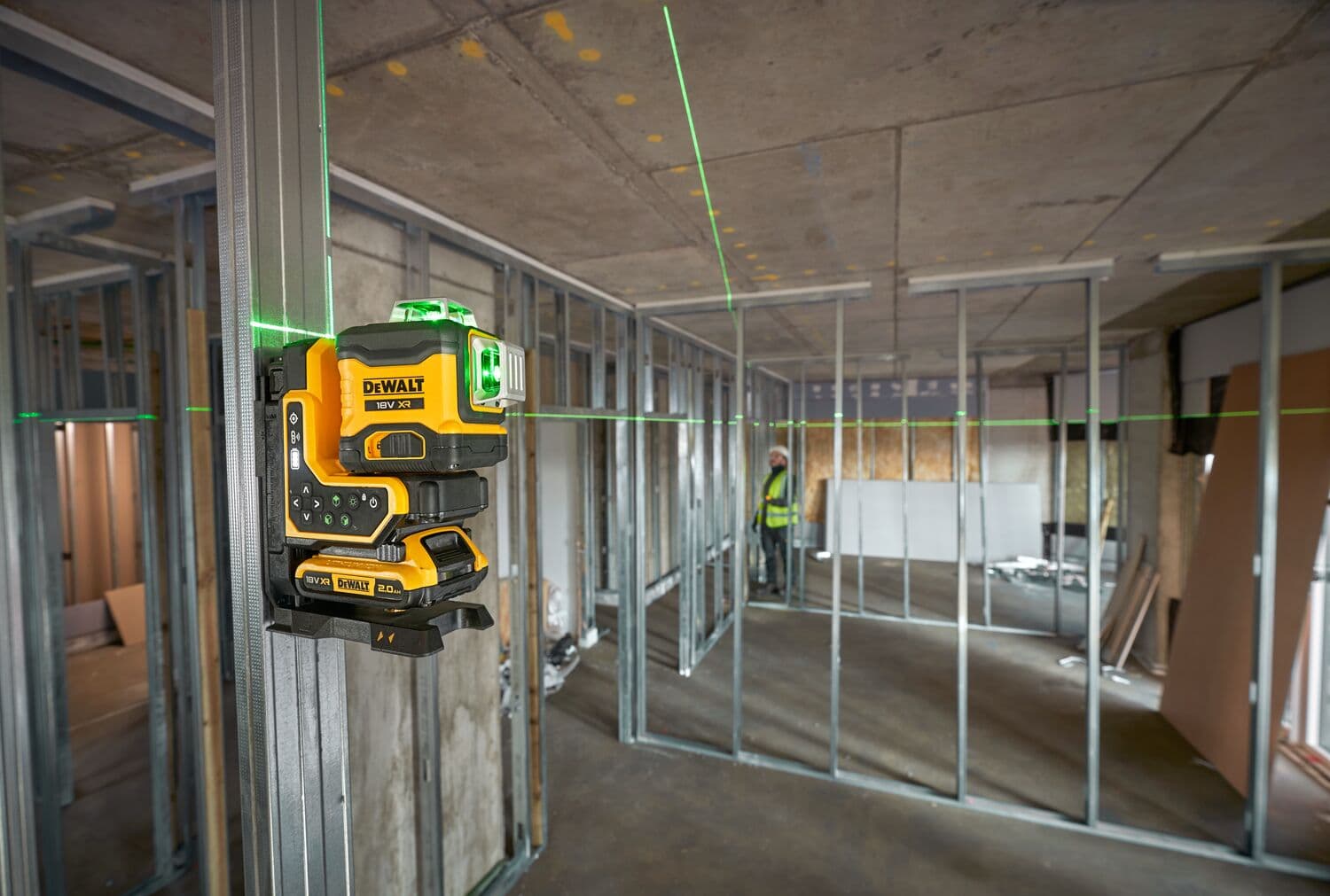 DEWALT green laser level mounted on metal stud for construction alignment in an unfinished building.