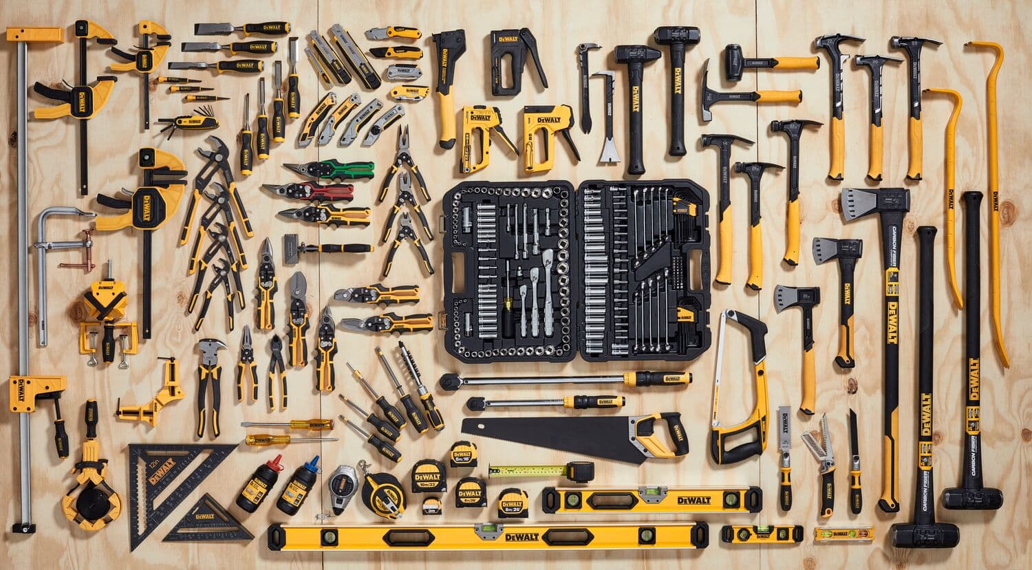 Assorted DEWALT hand tools and tool kit neatly arranged on a wooden surface for display.